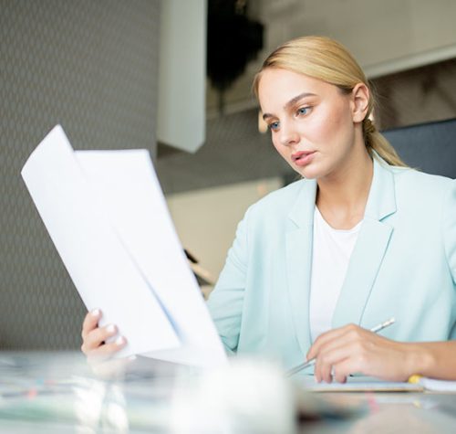 young-broker-or-businesswoman-looking-through-text-TFRK92N