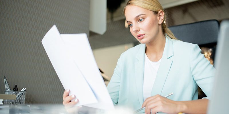 young-broker-or-businesswoman-looking-through-text-TFRK92N
